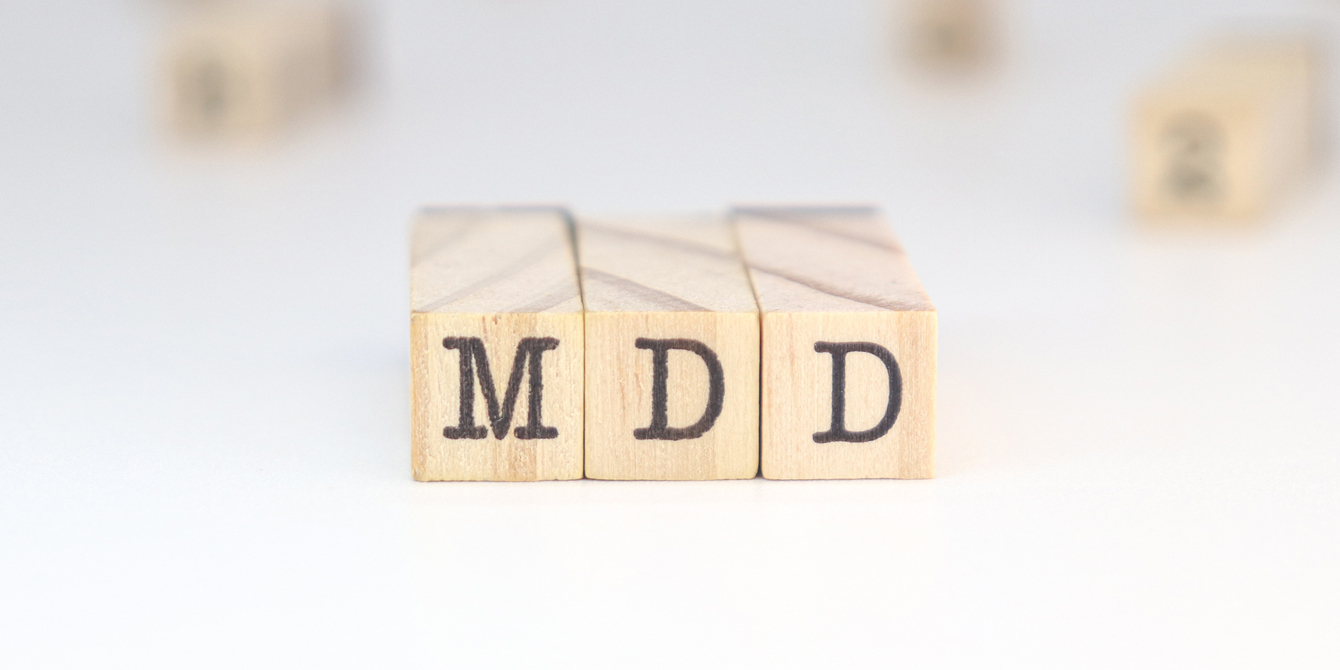 Wooden blocks stamped with the letters MDD for major depressive disorder.